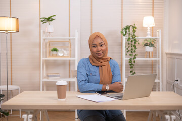 Portrait Of Young Black Muslim Woman In Hijab Using Laptop At Home .Work  at home concept.