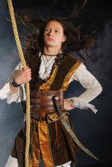 Young pirate captain with gun holding onto rope