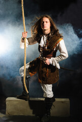 Young pirate captain with gun holding onto rope