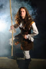 Young pirate captain with gun holding onto rope