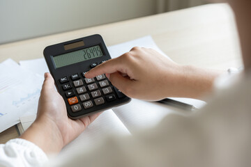 Woman calculate bill budget payment, home accounting concept with calculator.