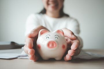 Money save concept woman put coin in piggy bank. Coin currency deposit for household expense.