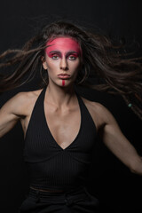 Fototapeta premium Ethnicity, tribe, make-up concept. Beautiful native American Indian woman studio portrait. Model with tribe red paint make-up and hair with dreadlocks jumping in air and looking at camera