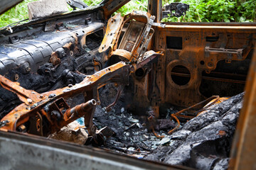 Car after a fire. Burnt rusty car after fire or accident. Car after the fire, crime of vandalism, riots. Arson car. Accident on the road due to speeding. Explosion.