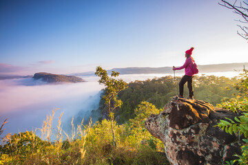 Young woman in red jacket hiking on Pha Muak mountain, border of Thailand and Laos, Loei province,...