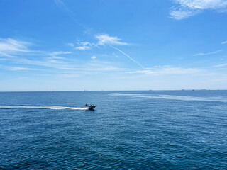 青い海と空を横切る１隻の釣り船