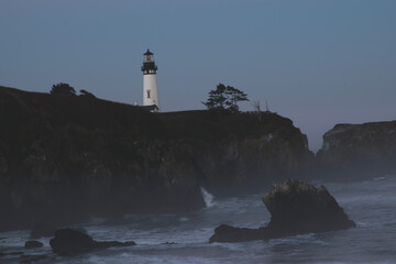 Sunrise at the Yaquina Head Lighthouse in Newport, Oregon.  The lighthouse is on a rocky...