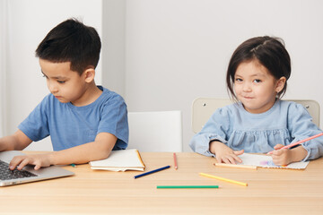 Naklejka premium cute children boy and girl sit at a desk in class and play around