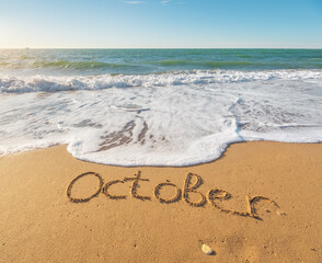 October word on sea sand.