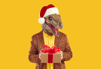 Portrait of man wearing dinosaur mask, red Santa Claus cap and funky leopard jacket standing...