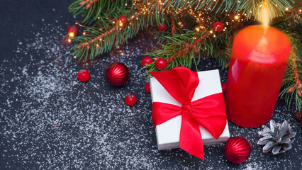 Spruce, fir branches, red berries, gift box on Christmas lights background. Frame border. Christmas New Year composition background. Space for text. Banner.