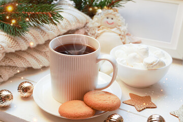   Winter, Christmas, New Year decorations composition, concept, background. White Mug, cup of tea, coffee, steam, meringue, knitted plaid. Christmas lights. Christmas mood morning. Christmas  card.
