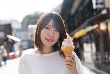 観光地でソフトクリームを食べる女性