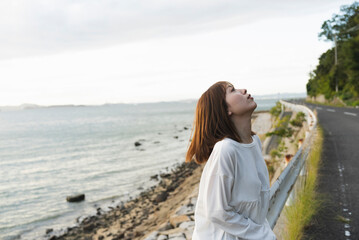 夕暮れの海岸線にいる女性