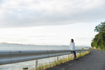 夕暮れの海岸線にいる女性