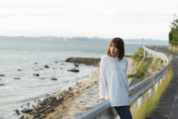 夕暮れの海岸線にいる女性