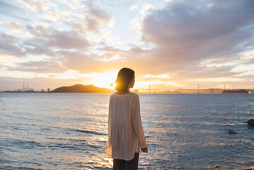 夕暮れの海にいる女性