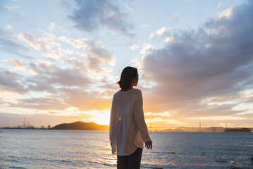 Fototapeta premium 夕暮れの海にいる女性