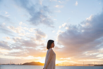 夕暮れの海にいる女性