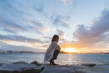 夕暮れの海にいる女性