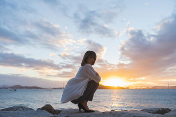 夕暮れの海にいる女性