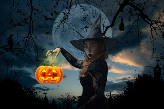 Halloween witch with pumpkin monster head over cross, church, crow, bat, birds, dead tree, full moon and sunset sky, Halloween mystery concept