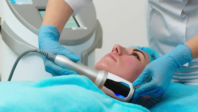 Why not pamper yourself with facial or body treatment. red haired woman with pefect freckled skin getting skin rejuvenation with RF lifting apparatus at at professional beauty salon, top view