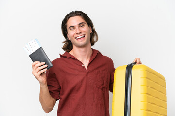 Young handsome man isolated on white background in vacation with suitcase and passport