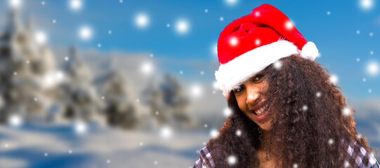 smiling black or african american girl in santa claus hat with snowflakes. people, season and christmas concept