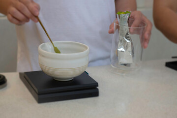 Man hand brews matcha tea