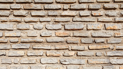Old wall made of natural limestone, regular stone surface.