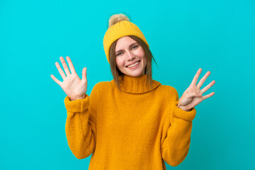 Young English woman wearing winter jacket isolated on blue background counting nine with fingers