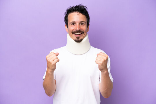 Young Caucasian Man Wearing Neck Brace Isolated On Purple Background Celebrating A Victory In Winner Position