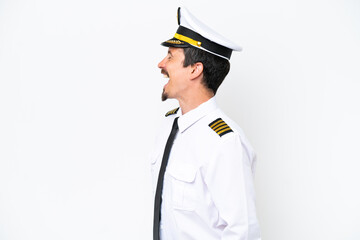 Airplane caucasian pilot isolated on white background laughing in lateral position