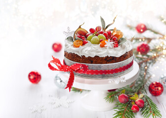 Traditional Christmas fruit cake with white frosting and sugared fruits.