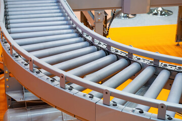 Conveyor for warehouse enterprise. Empty conveyor. Production line with gray rollers. Fragment...