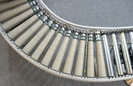 Fragment of empty conveyor. Production line for factory or plant. Conveyor close-up. Production conveyor for moving goods. Empty production line on grey. Manufacturing technologies.