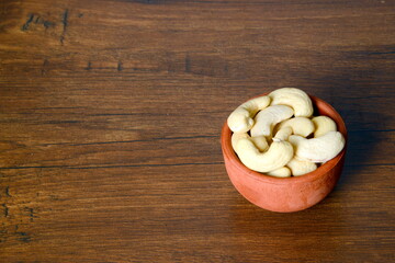 Fresh almonds in the wooden bowl, Organic almonds, almonds border white background, Almond nuts on a dark wooden background. Healthy snacks. Top view. Free space for text.