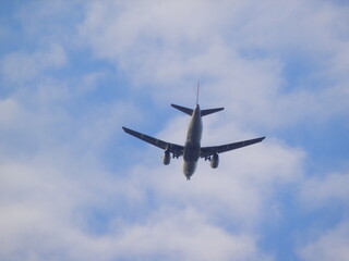 Fototapeta na wymiar Airplane in the sky passing over a city