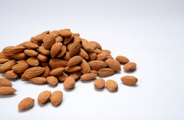Fresh almonds in the wooden bowl, Organic almonds, almonds border white background, Almond nuts on a dark wooden background. Healthy snacks. Top view. Free space for text.