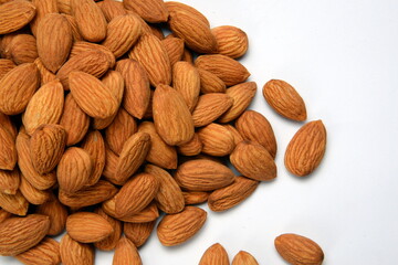 Fresh almonds in the wooden bowl, Organic almonds, almonds border white background, Almond nuts on a dark wooden background. Healthy snacks. Top view. Free space for text.