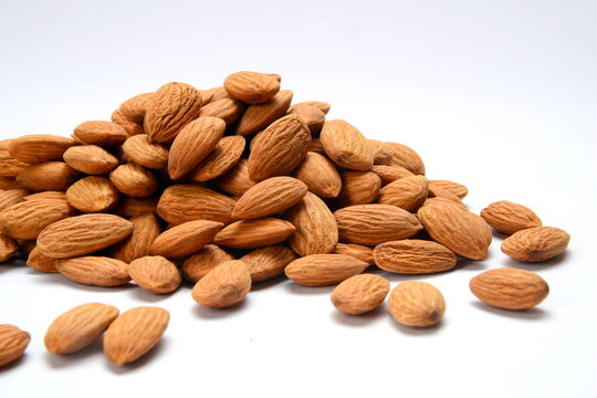 Fresh almonds in the wooden bowl, Organic almonds, almonds border white background, Almond nuts on a dark wooden background. Healthy snacks. Top view. Free space for text.