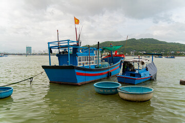 Naklejka na ściany i meble Seaport of fishing vessels in Vietnam. The southern part of Nha Trang city on a cloudy day. 