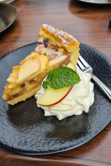 Piece of apple pie with a ball of ice cream and caramel sauce on a plate, autumn baking concept.