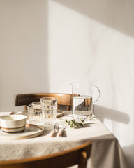 serving dishes on a linen tablecloth, beautiful shadows from the window, glare on the glass