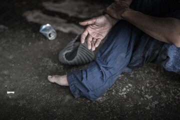 Homeless senior adult man sitting and begging in overpass