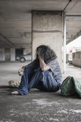 Homeless people sit on the streets in the shadows of buildings and ask for help and money the...