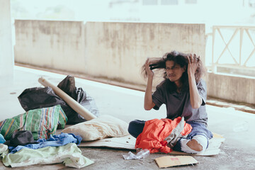 Homeless people sit on the streets in the shadows of buildings and ask for help and money the troubles of the big modern city.