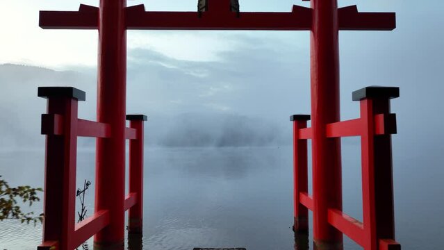 Japanese shrine, traditional Japanese torii on a lake, flying through torii in Japan on a foggy mystical morning, Japanese iconic tourist landmark