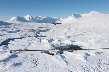 Beautiful aerial drone Winter landscape images of Loch Ba and snow covered mountains in background...